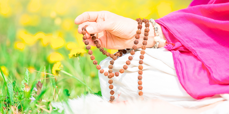 a women holding a rosary and meditating