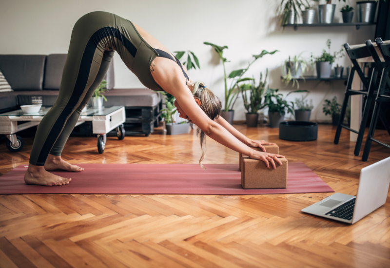 a girl doing a supported downward dog using blocks