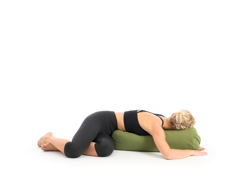 a girl doing supported twist with a bolster