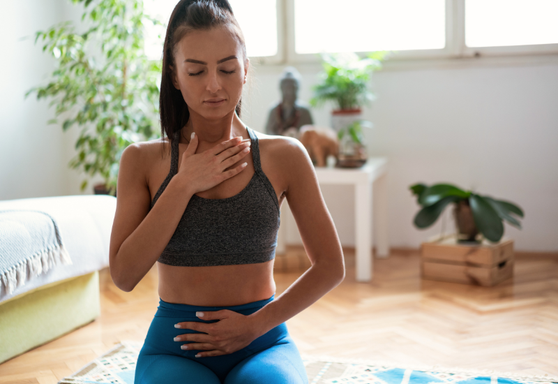 a girl sitting at home and practicing breathing exercises
