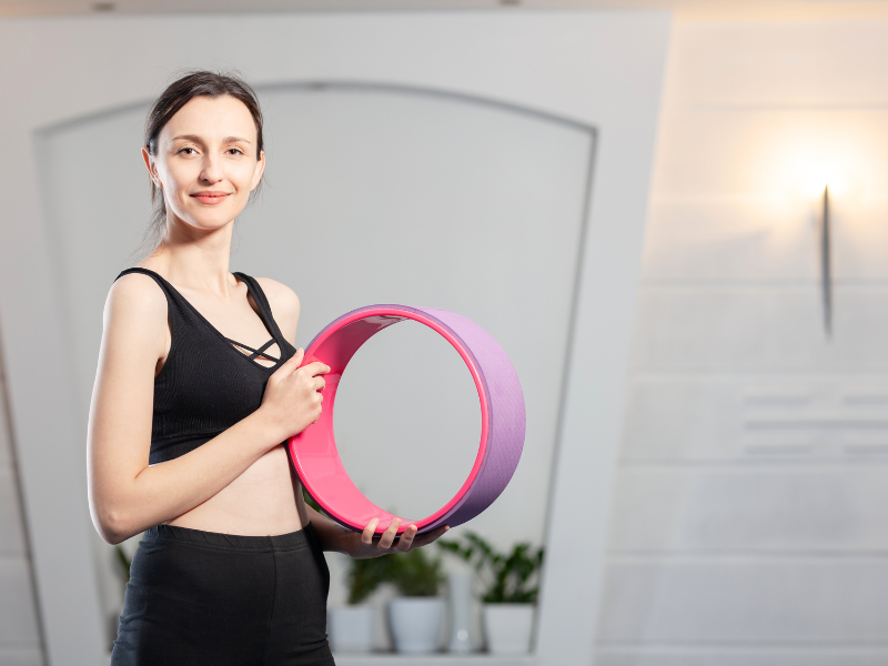 a girl holding a yoga wheel