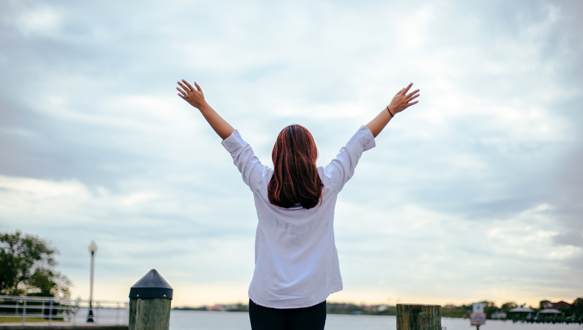 a woman standing with arms open
