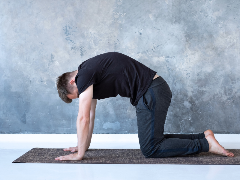 a man doing cat pose for better posture