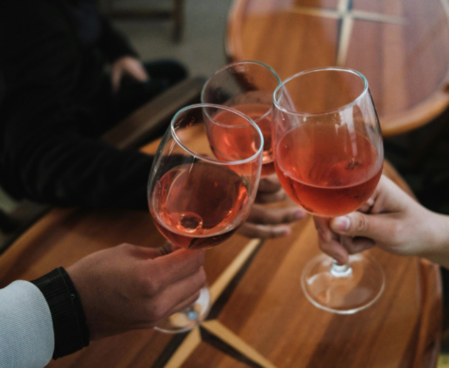 people clanking glasses filled with alcoholic drinks