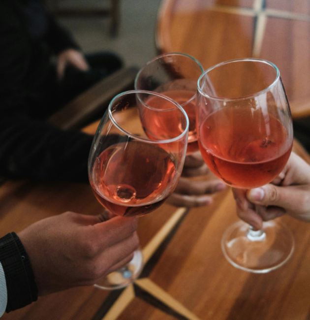 people clanking glasses filled with alcoholic drinks