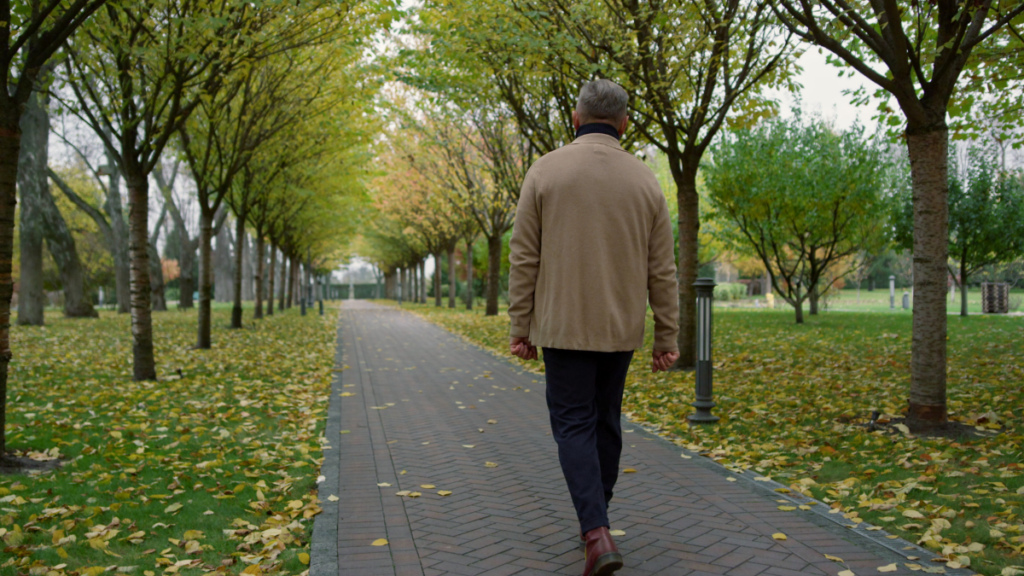 Man walking down tree-lined path