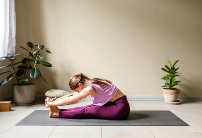 a girl doing seated forward bend or paschimottanasana