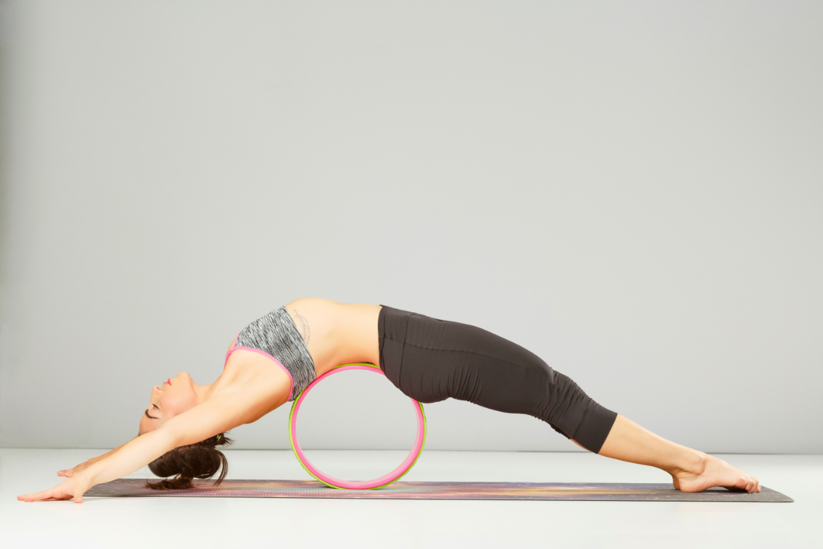 a girl doing fish pose doing yoga wheel