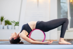 a girl doing assisted wheel pose